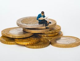 Economía personal - Cómo ahorrar rápido - Hombre sentado en una montaña de monedas
